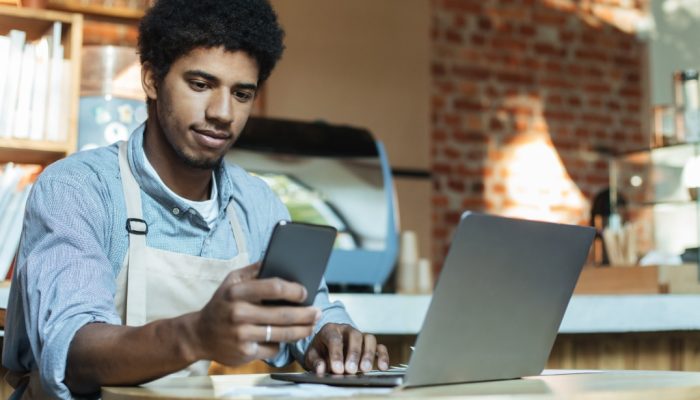 dono de negócio mexendo no celular para abrir conta digital