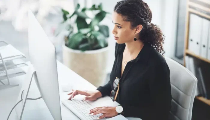 mulher mexendo no computador calculando encargos trabalhistas