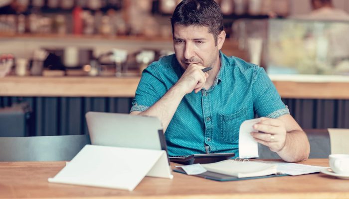 homem conferindo contas no tablet para calcular o simples nacional